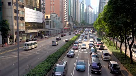 Busy-traffic-jam-on-main-highway-road-with-tall-skyscrapers-towering-row-in-major-Asia-financial-hub-in-Hong-Kong,-China