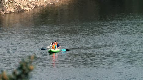 A-couple-is-resting-on-a-kayak-in-the-Lozoya-river,-in-Spain