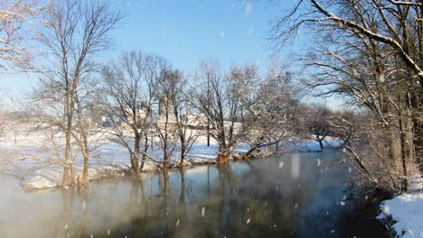 Luftaufnahme-Eines-Mystischen-Ländlichen-Flusses-Mit-Blattlosen-Bäumen-Bei-Schneefall