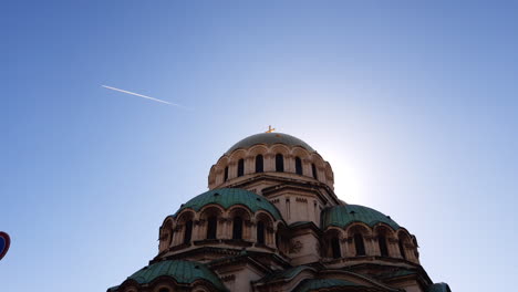 Alexander-Nevsky-Cathedral-in-Sofia,-Bulgaria-on-a-sunny-day-and-a-plane-flies-in-the-blue-sky
