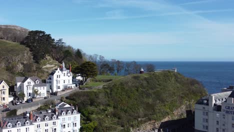 Aerial-view-of-The-Grand-hotel-landmark-Llandudno-seafront-seaside-Victorian-promenade-tourism-building-pan-right-tilt-down