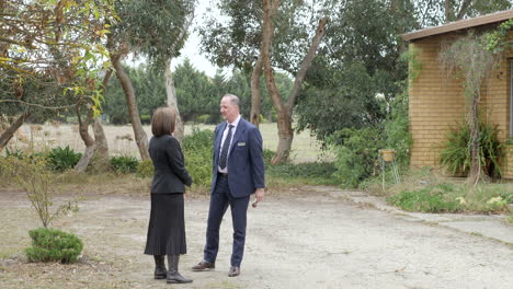 Two-Real-Estate-Agents-Laughing-Before-Property-Auction,-SLOW-MOTION