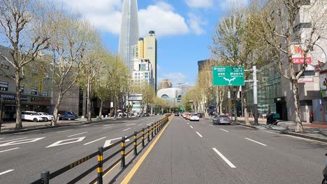 Car-Driving-On-City-Road-At-Daytime-With-Lotte-World-Tower-Seen-On-Left-Side