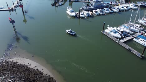 Luftaufnahme-Aus-Der-Vogelperspektive-über-Einem-Kleinen-Fischerboot,-Das-Den-Sonnigen-Luxusyachthafen-Am-Wasser-Verlässt