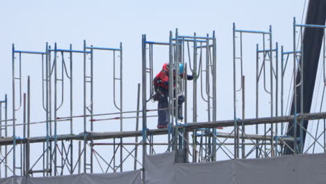 Arbeiter-Mit-Schutzhelm-Arbeiten-Allein-Auf-Gerüsten-Auf-Der-Baustelle