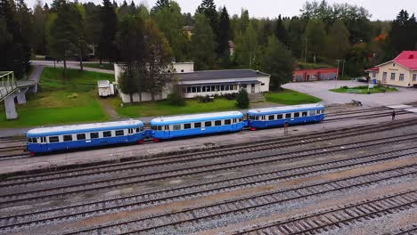 Aerial-tracking-drone-view-of-historical-DM7-passenger-train-also-known-as-"Lättähattu"-departing-from-Haapamäki-railway-station