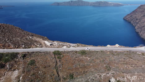 Driving-on-Santorini-coastline,-travel-concept.-White-vehicle
