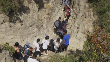 Hiker-group-in-Ethopia-is-descending-to-the-lake-in-very-narrow-passage-forming-a-line-and-the-seniors-are-watching-and-managing-them