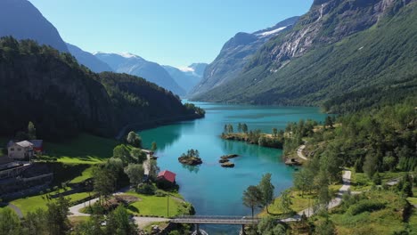 Turquoise-Loen-lake-in-majestic-Norwegian-mountain-landscape---Crispy-clear-water-straight-from-surrounding-glaciers---Reverse-aerial-showing-lake-with-surrounding-mountains-and-river---Birds-passing