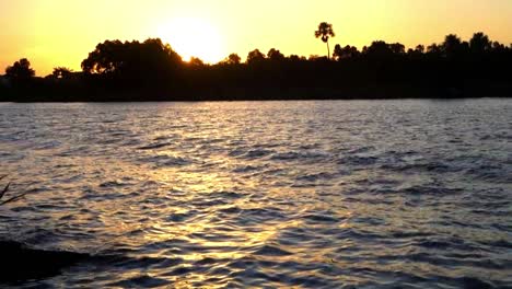 Kleine-Wellen-Mit-Schaum-Und-Spritzern-Zerquetschen-Den-Tropischen-Fluss-In-Zeitlupe-Während-Eines-Wunderschönen-Warmen-Gelben-Sonnenuntergangs