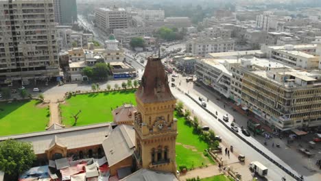 Vista-Aérea-Sobre-La-Torre-Del-Reloj-Del-Mercado-De-La-Emperatriz-Y-Los-Jardines-Verdes-En-La-Ciudad-De-Saddar