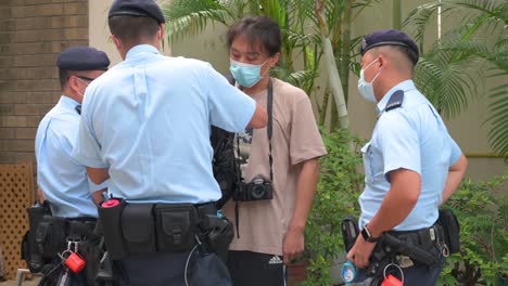 Polizisten-Halten-An-Und-Durchsuchen-Einen-Mann,-Als-Die-Regierung-Die-Jährliche-Mahnwache-Bei-Kerzenlicht-Im-Victoria-Park-Anlässlich-Des-Massakers-Auf-Dem-Platz-Des-Himmlischen-Friedens-1989-In-Hongkong-Verbot