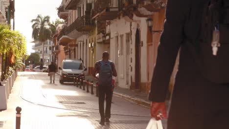 A-diverse-group-of-business-professionals-walking-down-a-paved-road-on-their-morning-commute-to-work,-Casco-Viejo,-Panama-City