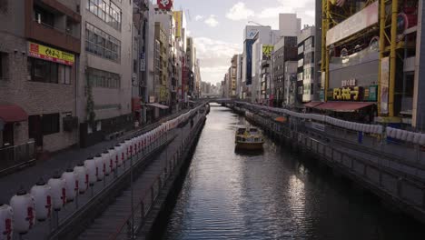 Dotonbori-River-at-sunset,-Osaka-streets-and-Skyline