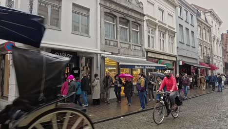 Horse-carriage-with-tourists-passing-in-slow-motion-in-a-street-of-Bruges-in-Belgium