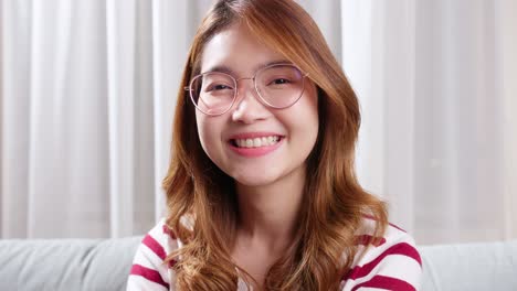 Mujer-Joven-Asiática-Con-Anteojos-Recetados-Mirando-A-La-Cámara-Y-Sonriendo