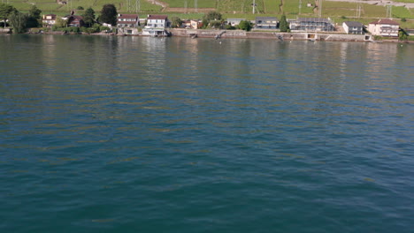 Drohne-Fliegt-über-Den-Genfer-See,-Kippt-Nach-Oben-Und-Fliegt-über-Wunderschöne-Häuser-Am-Seeufer