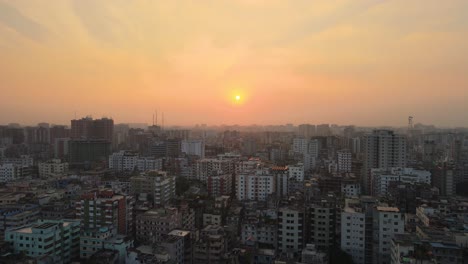 Luftaufnahme-Der-Stadt-Eines-Entwicklungslandes-Während-Eines-Intensiven-Orangefarbenen-Sonnenuntergangs,-Asien