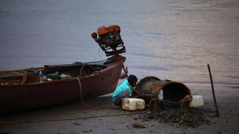 Un-Hombre-Local-Soldando-Metal-En-La-Orilla-Junto-A-Su-Bote-A-Lo-Largo-Del-Río-Pak-Nam-En-Krabi