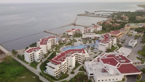AERIAL---A-hotel-and-its-swimming-pools-in-Cancun,-Mexico,-lowering-shot
