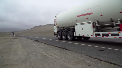 Truck-hauling-a-gas-tanker-along-a-desert-road-in-Gramita,-Casma,-Ancash,-Peru