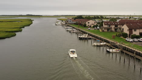 An-aerial-view-of-a-fishing-boat-sailing-in-a-marsh-in-Freeport,-NY