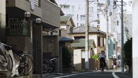 Ein-Einsamer-Radfahrer-Mit-Maske-In-Tokio-Auf-Einer-Ruhigen-Japanischen-Stadtstraße-Während-Der-Pandemie