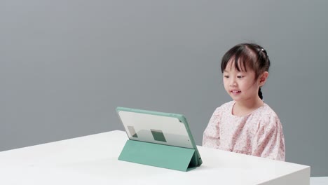 Kind,-Das-Ein-Digitales-Tablet-Verwendet,-Das-Neben-Dem-Tisch-Sitzt,-Um-Zeichentrickfilme-Anzusehen