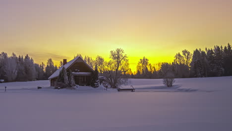 Zeitraffer-Eines-Winterwunderlandes-Mit-Einem-Von-Natur-Umgebenen-Holzhaus-Und-Einem-Spektakulären-Sonnenuntergang-Im-Hintergrund
