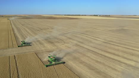 Combines-harvesting-huge-field-of-wheat-in-Saskatchewan,-Canada