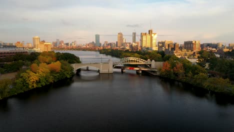 Drone-shot-of-Boston,-MA-skyline-at-sunset-with-bridge-in-view
