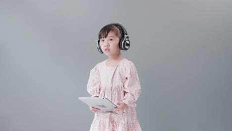 A-child-with-a-headset-watching-videos-with-a-digital-tablet