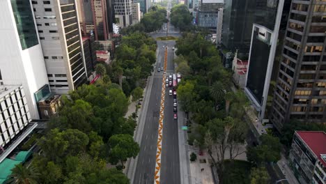 Cars-crossing-Reforma-avenue-of-Mexico-city,-principal-street-with-Cempasuchil-flowers-of-the-day-of-the-dead-celebration