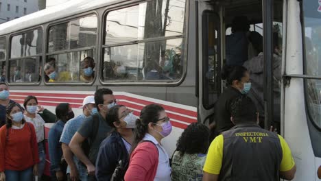 Lateinamerikaner-Stehen-Mit-Gesichtsmaske-Schlange,-Um-In-Den-Bus-Einzusteigen,-El-Salvador