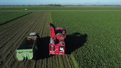 Eine-Kartoffelerntemaschine-Und-Ein-Traktor-Mit-Kastenwagen-Fahren-Nebeneinander