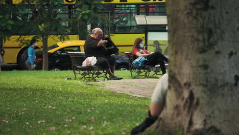 People-with-face-masks-sitting-on-benches-in-Las-Heras-Park,-Argentina