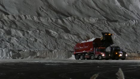 Lorries-dump-snow-in-a-quarry,-created-for-winter-season