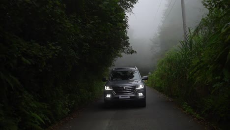 rear-of-standard-suv-on-asphalt-road-in-the-mountains-at-high-speed-on-foggy-days