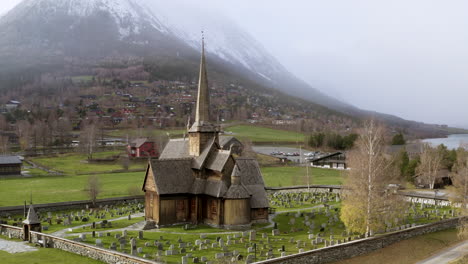 Stabkirche-Lom-Mit-Schneebedecktem-Berg-Im-Hintergrund-Während-Des-Herbstlichen-Schneesturms-In-Norwegen