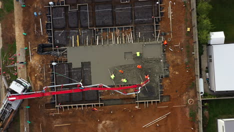 Luftaufnahme-Direkt-über-Betonbauarbeitern,-Die-Eine-Zementplatte-Für-Ein-Neues-Haus-Bauen