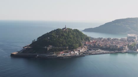 San-Sebastian-cityscape-and-island-with-tower-in-Atlantic-ocean,-aerial-drone