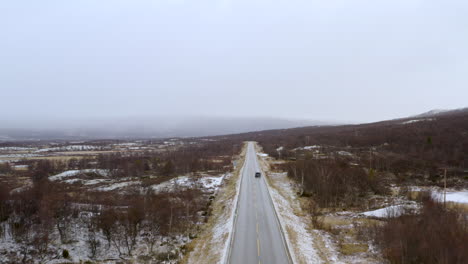 Car-On-The-Road-In-Winter-Forest-With-Snow-Covered-Landscape---Snowy-outdoor-scene---Traveling-concept-background---aerial-drone-shot