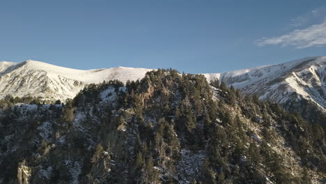 AERIAL---Beautiful,-forested-snowy-mountains,-epic-winter-scene,-Spain,-rising