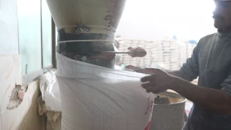 Male-Worker-Filling-Up-Grain-Sack-From-Dispenser-At-Flour-Mill