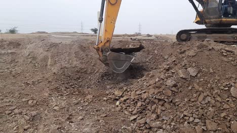 An-excavator-that-loadstone-and-soil-moorum-into-a-tractor-at-the-construction-site-in-India