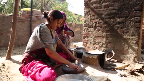 Vida-Doméstica-De-Jóvenes-Indias-Preparando-Pan-Chapati-Tradicional-Con-Rodillo,-Rajasthan
