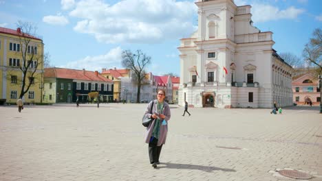 Alte-Touristin,-Die-Auf-Dem-Innenhof-Des-Rathauses-Der-Altstadt-Von-Kaunas-In-Litauen-Spaziert