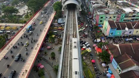 Public-train-entering-Ampera-railway-station-in-city-of-Palembang,-aerial-view