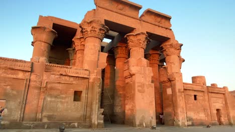 Entrada-Exterior-Del-Templo-De-Kom-Ombo-En-Egipto-Durante-La-Puesta-De-Sol,-Turistas-Caminando
