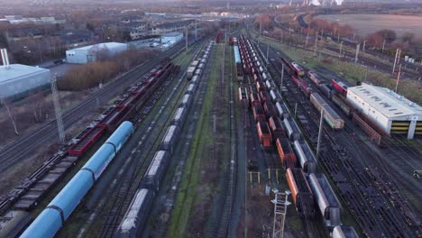 Aerial-view-over-long-train-yard-tracks-and-freight-shipping-tanker-railway-lines-slow-reverse